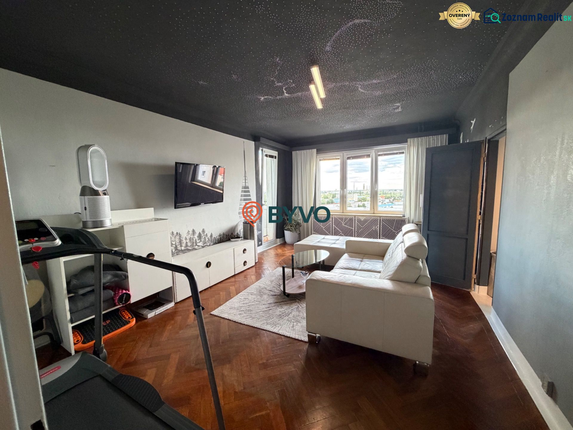 A stylishly furnished living room with a white sofa and a wooden decor floor.