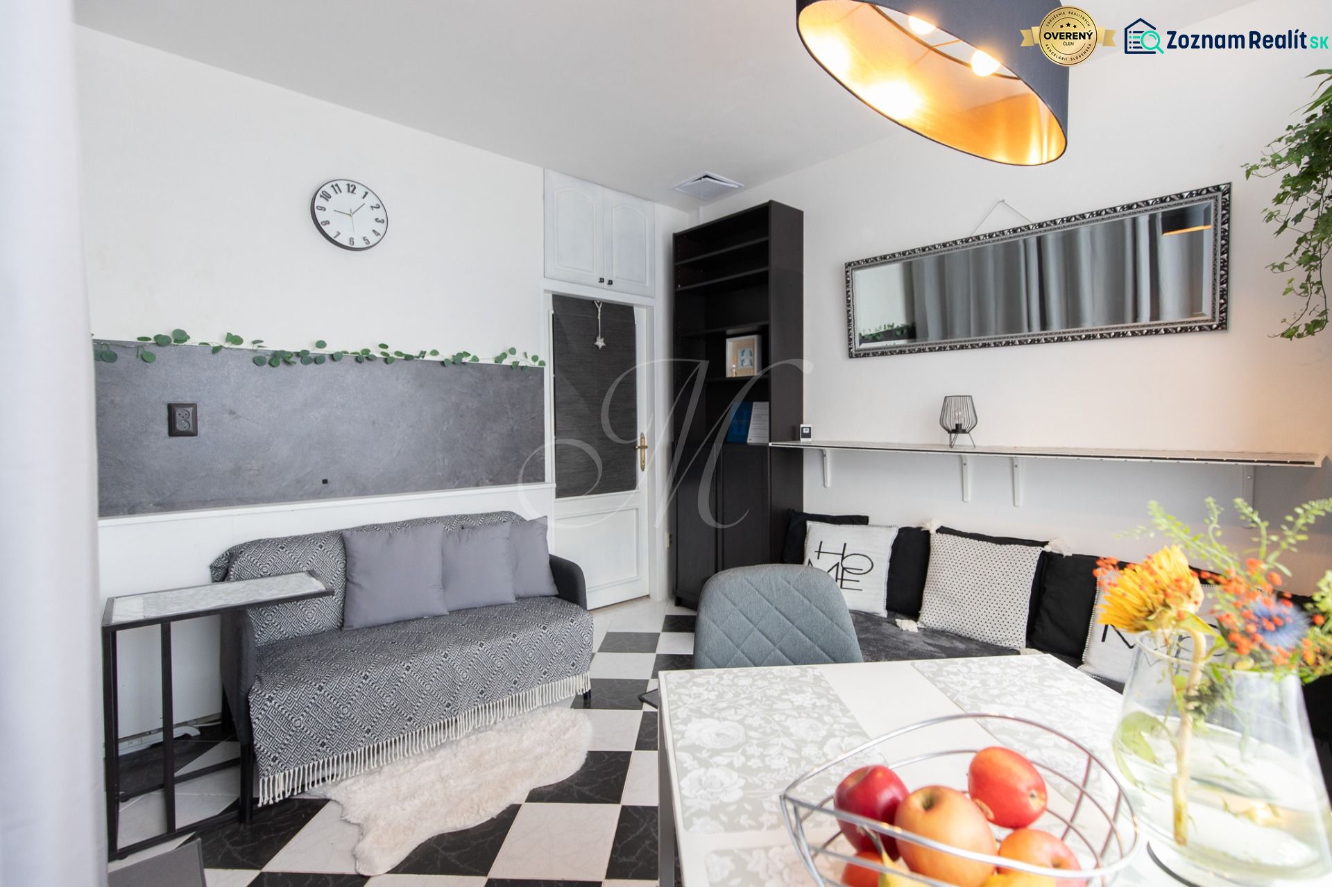 Living room in a two-room apartment with black and white flooring and decorations.