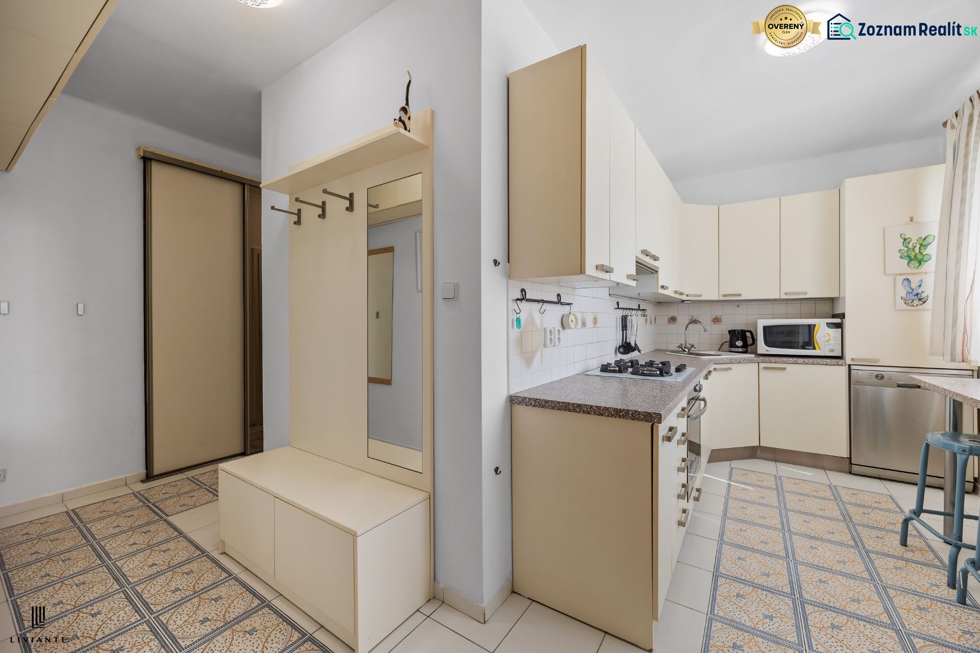 A kitchen in a 2-room apartment with white cabinets and built-in appliances.