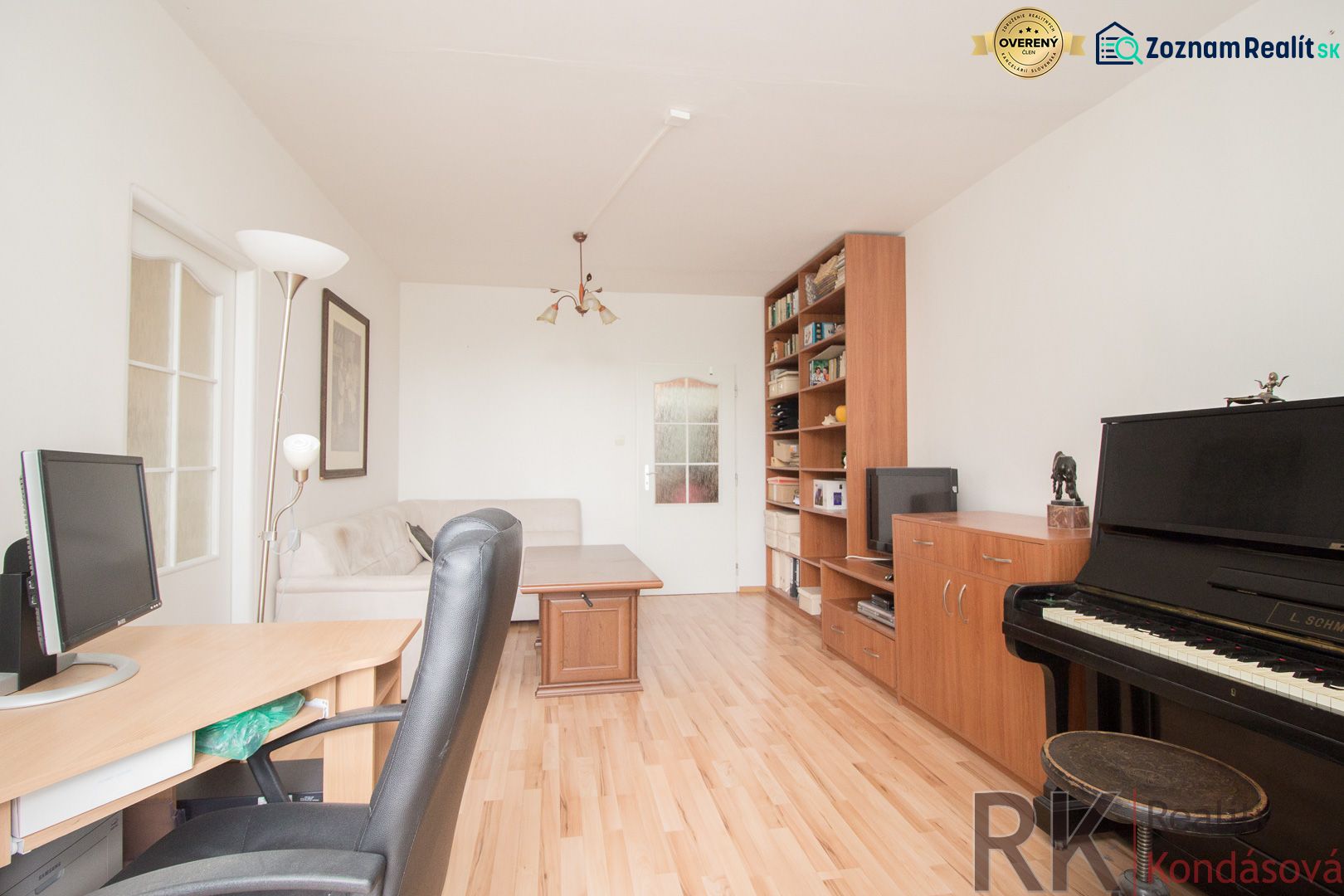 Living room in a 3-room apartment with a piano and a wooden decor floor.