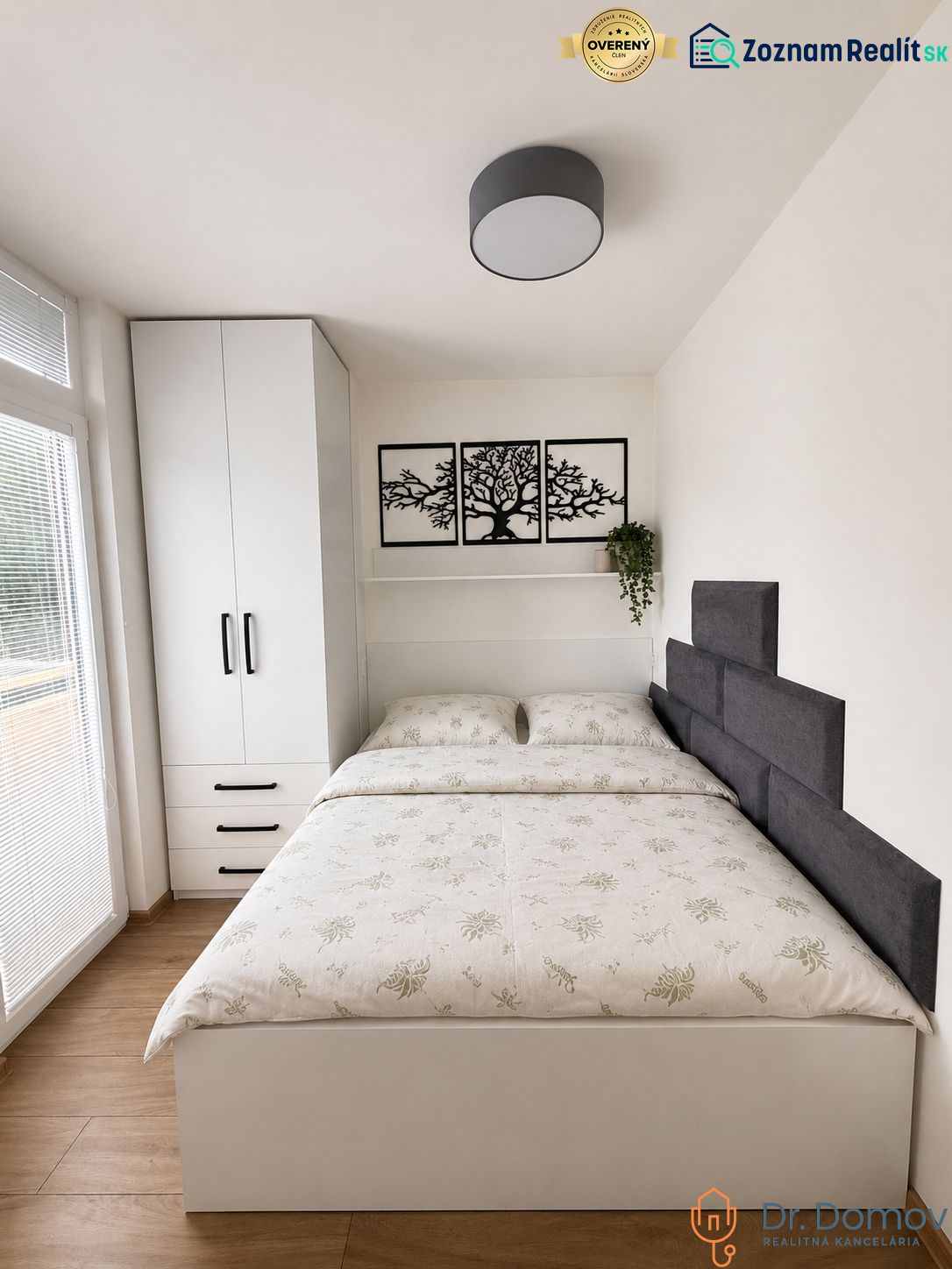A bedroom in a studio apartment with wall decoration and a wooden decor floor.