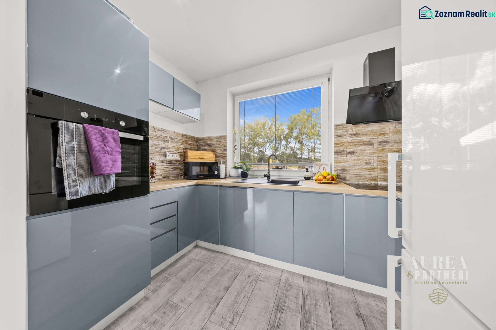 A kitchen in a family house with gray cabinets and a wooden decor floor.