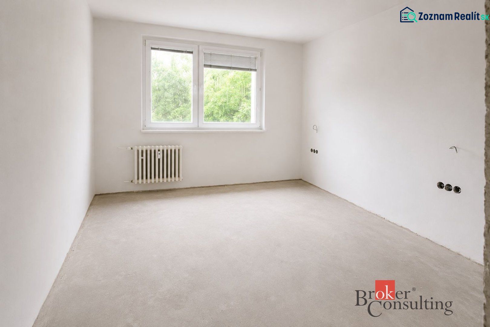 A kitchen in a 4-room apartment with a wooden decor floor and a large window.