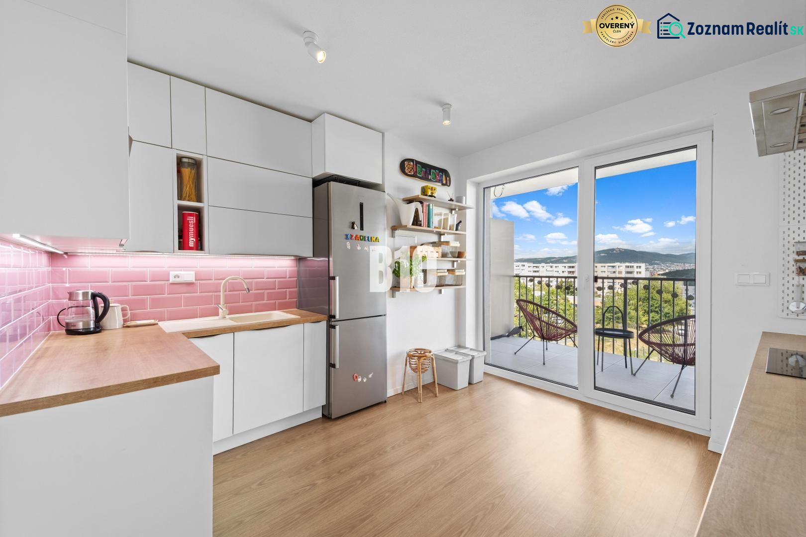 A kitchen in a 4-room apartment with a balcony and a wooden decor floor.