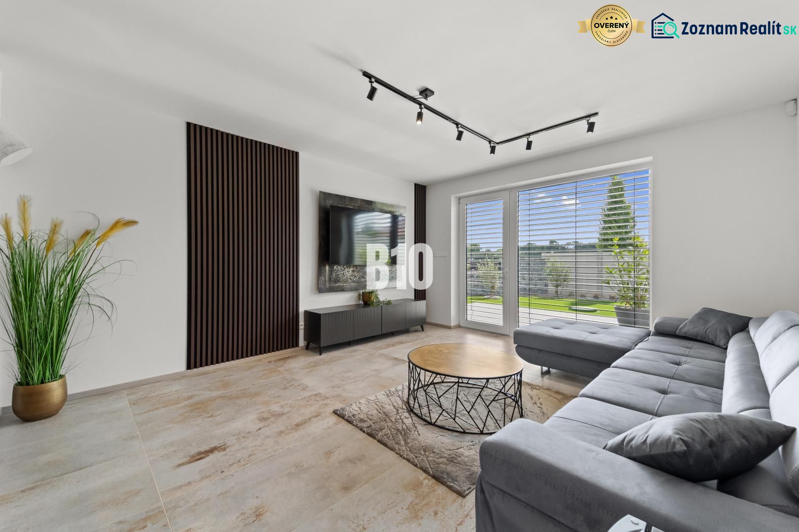 Living room in a family house with a sofa, television, and a window with a view.