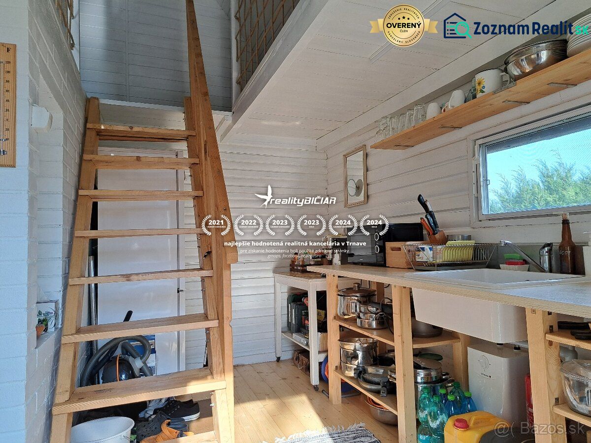 Interior of a cabin with a staircase, kitchen, and wooden decor flooring.