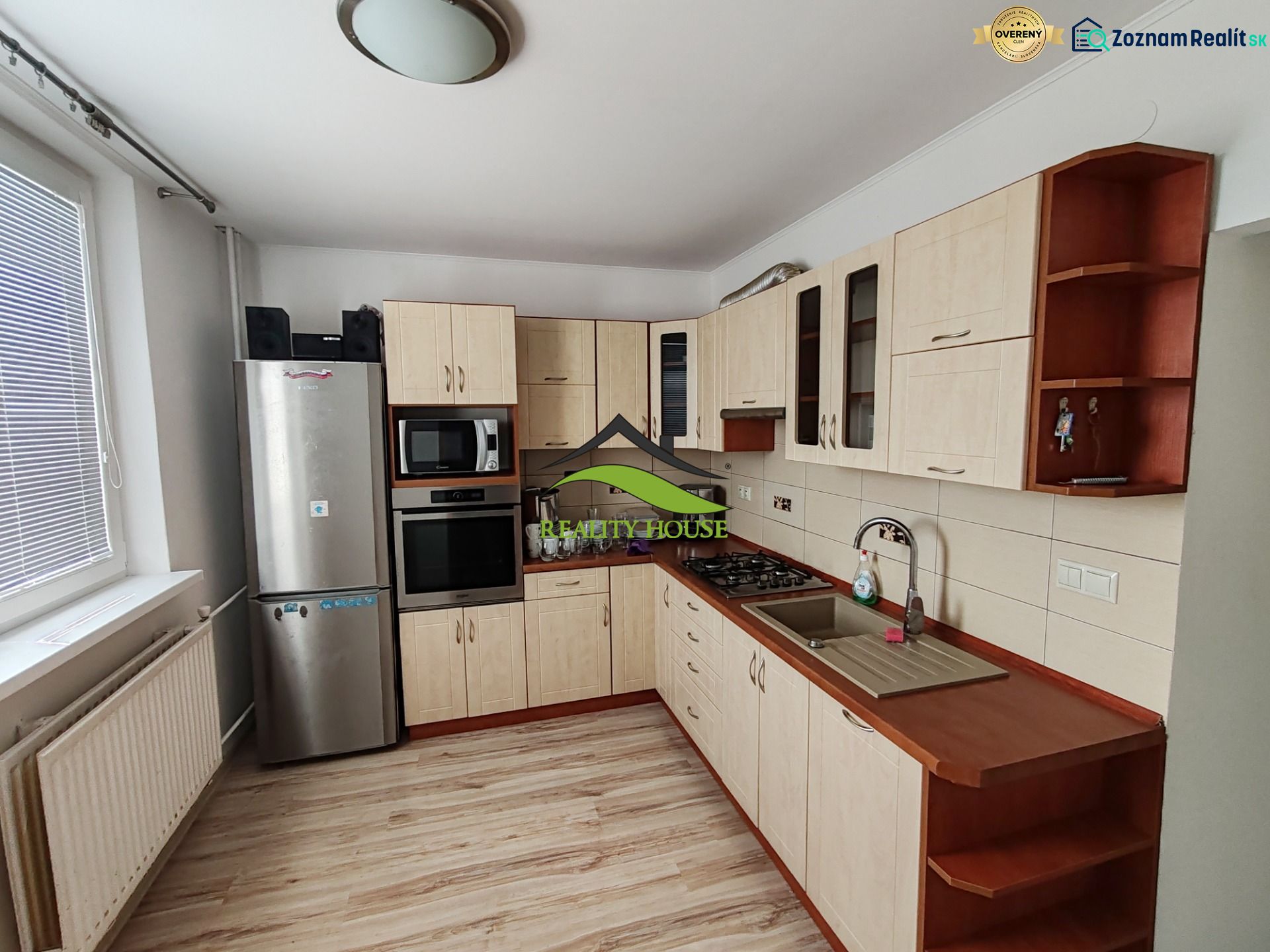A kitchen in a 3-room apartment with a wooden decor floor and appliances.