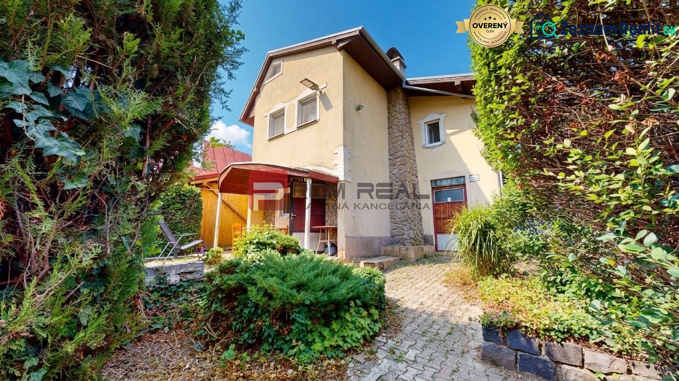 The cottage at Alžbeta's court in Miloslavov surrounded by greenery and a terrace.