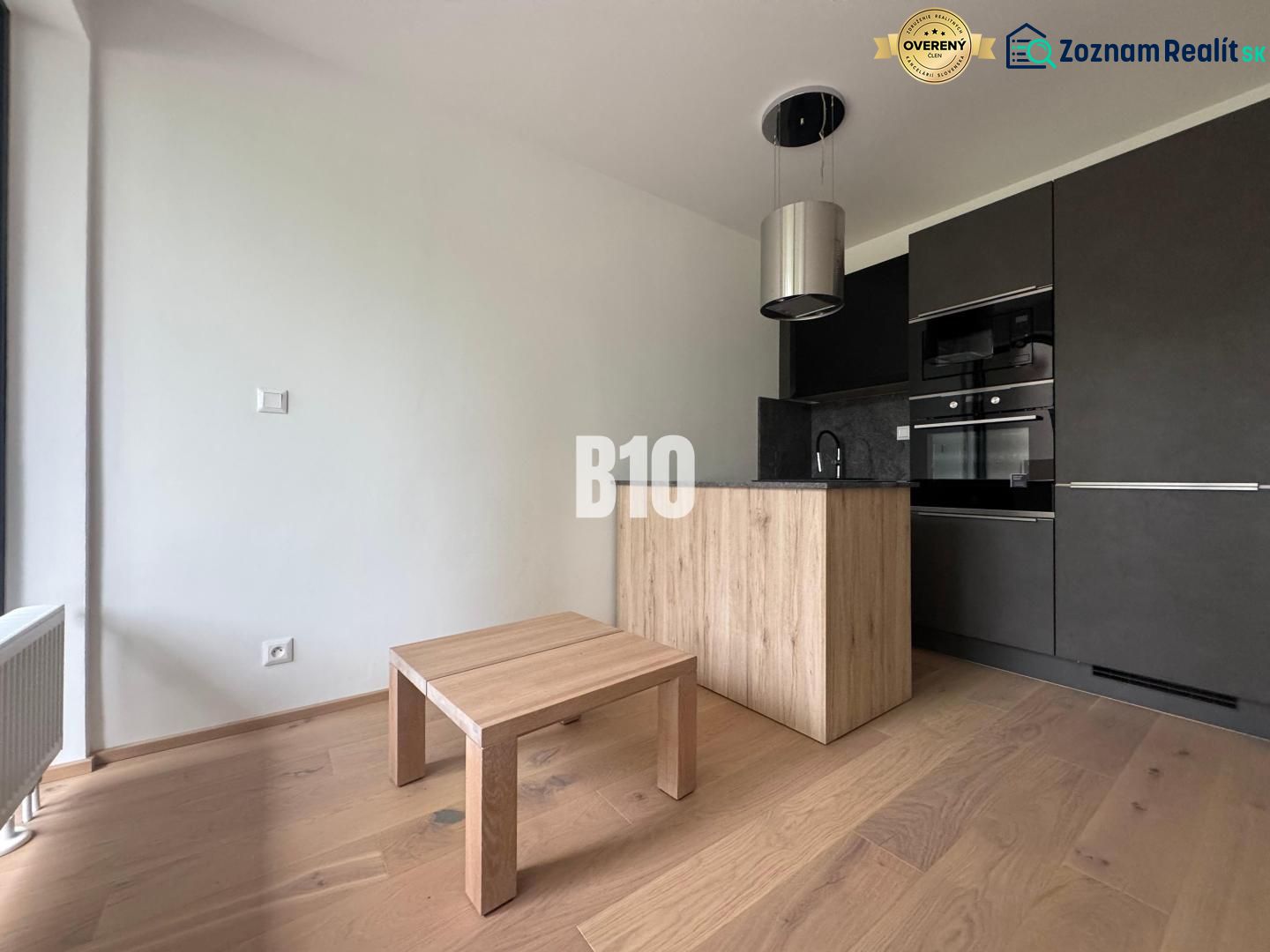A kitchen corner with dark cabinets and a wooden decor floor in a 2-room apartment.