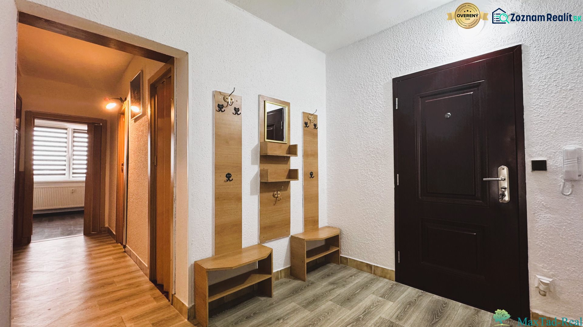 Entrance hall with a mirror and a coat rack, 4-room apartment with wood-patterned flooring.