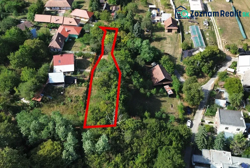 An aerial view of gardens in Kolačno surrounded by houses and greenery.