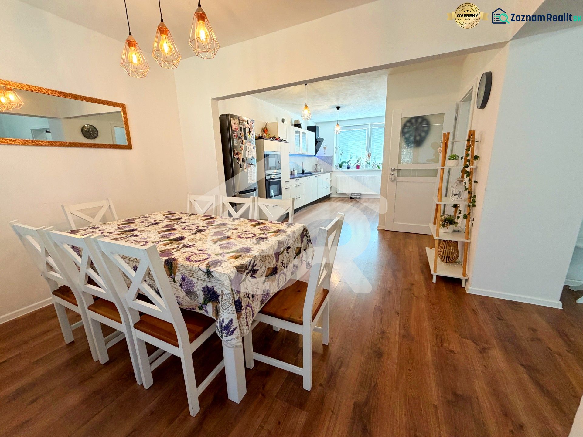 Dining room with wood-patterned flooring in a family house, with chairs and a dining table.