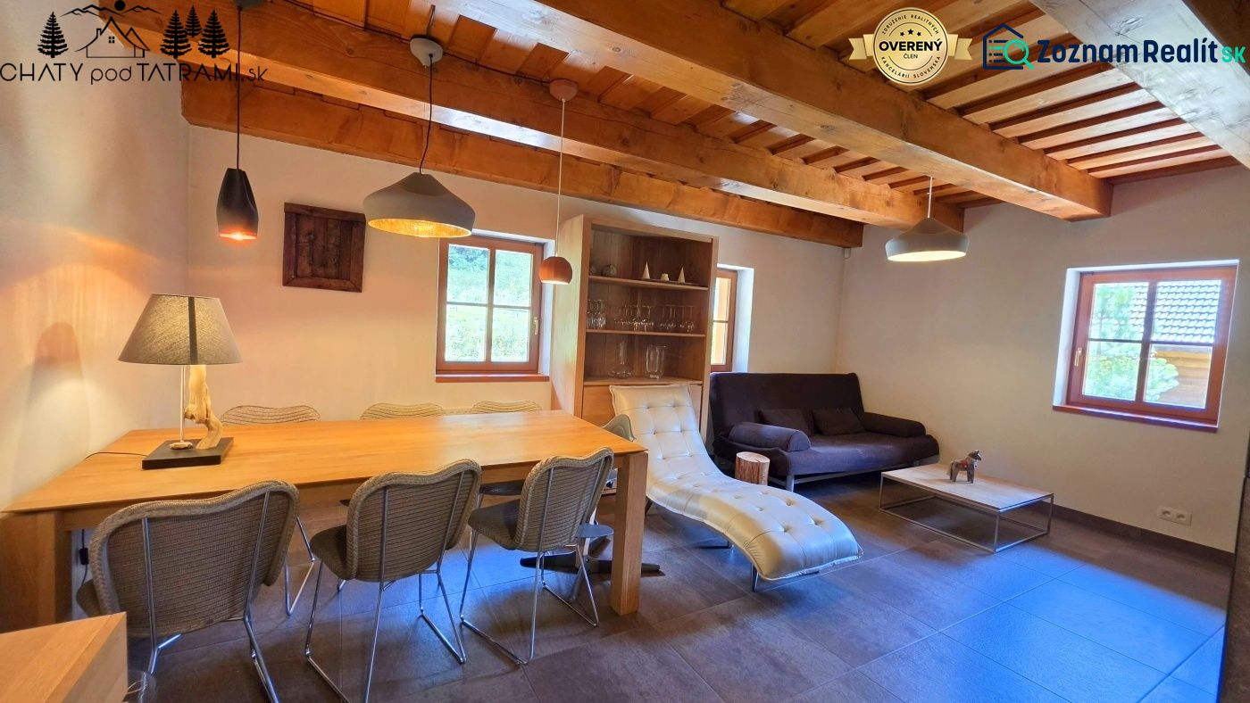 The interior of a cabin with a wood-decorated ceiling, comfortable furniture, and decorative lighting.