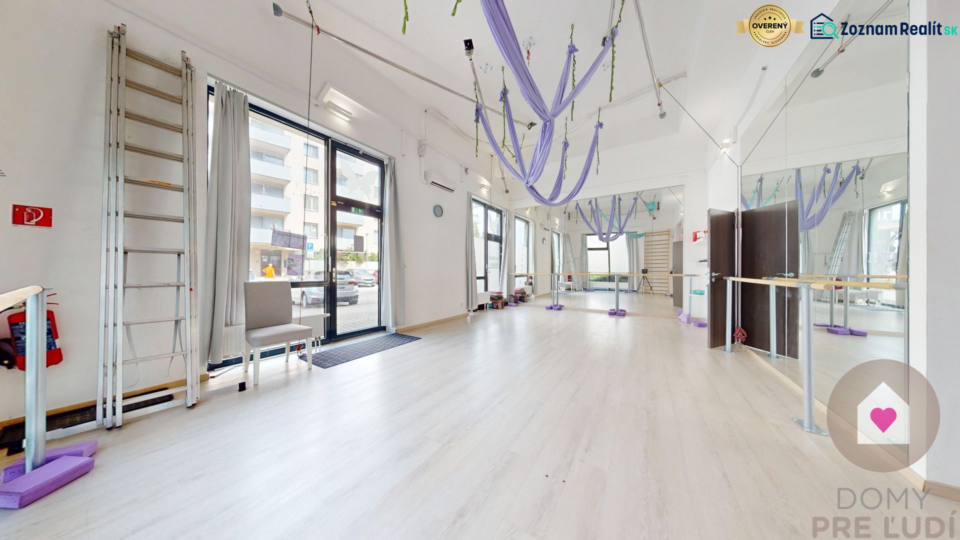 Interior of commercial spaces with wood-patterned flooring and mirrors, suitable for exercise.