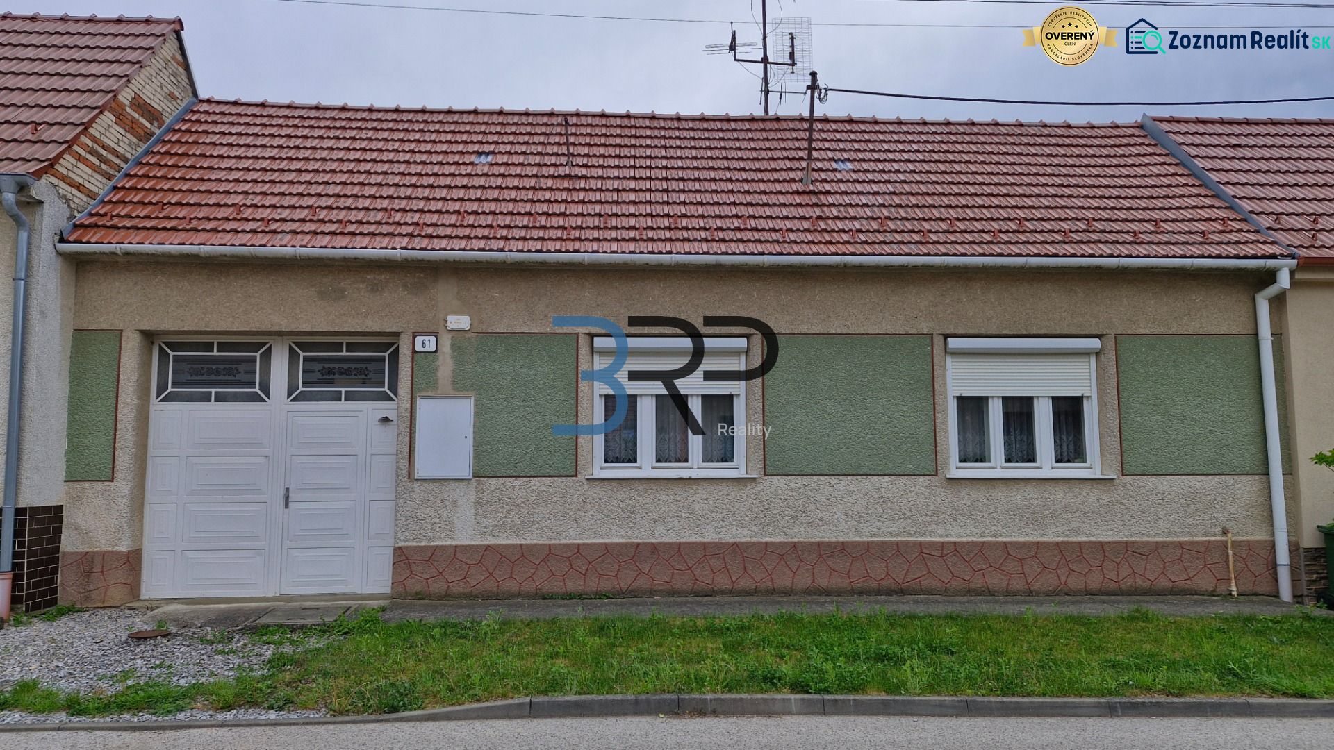 A family house in Mokrý Háj with a red roof and garage doors.