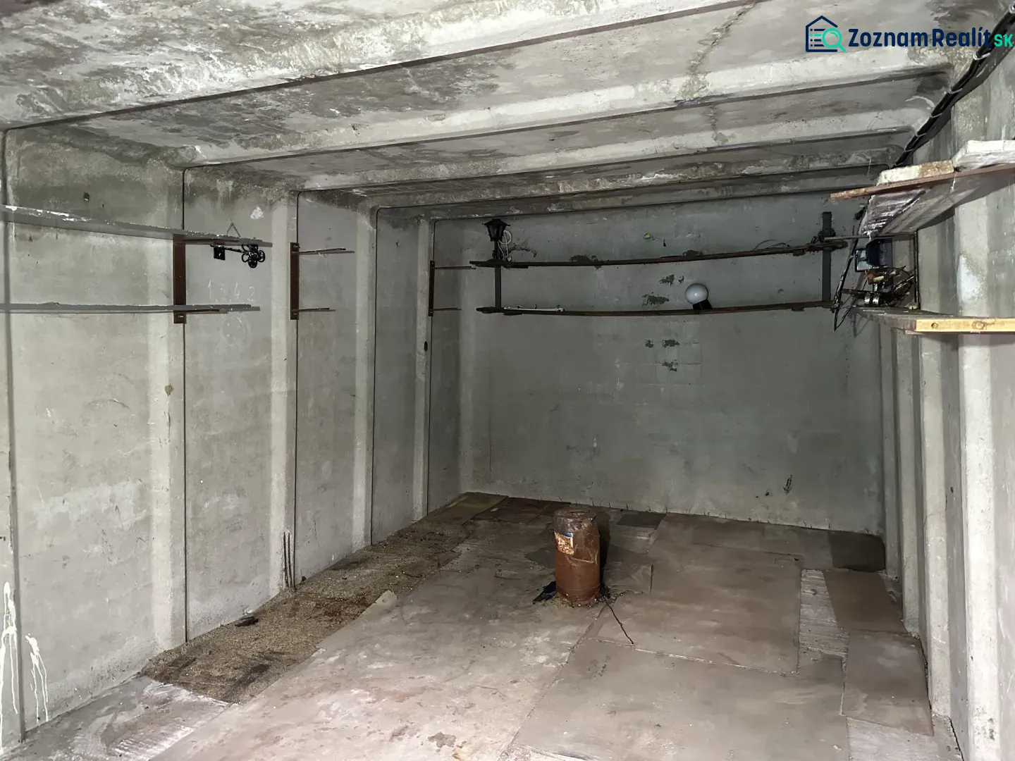 An empty concrete room with pipes and lighting, garage interior.