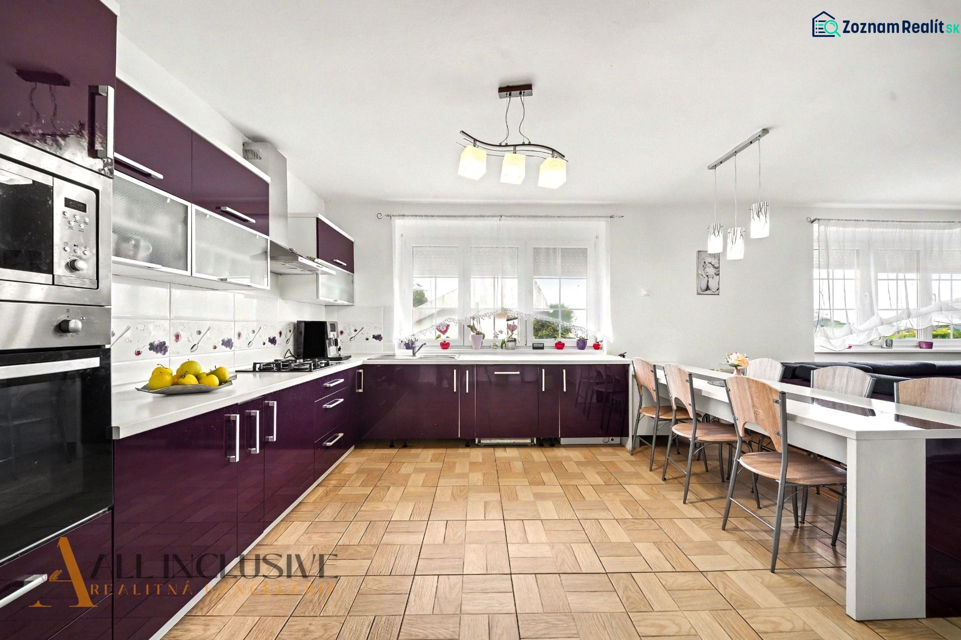 A kitchen in a family house with burgundy cabinets and a wooden decor floor.