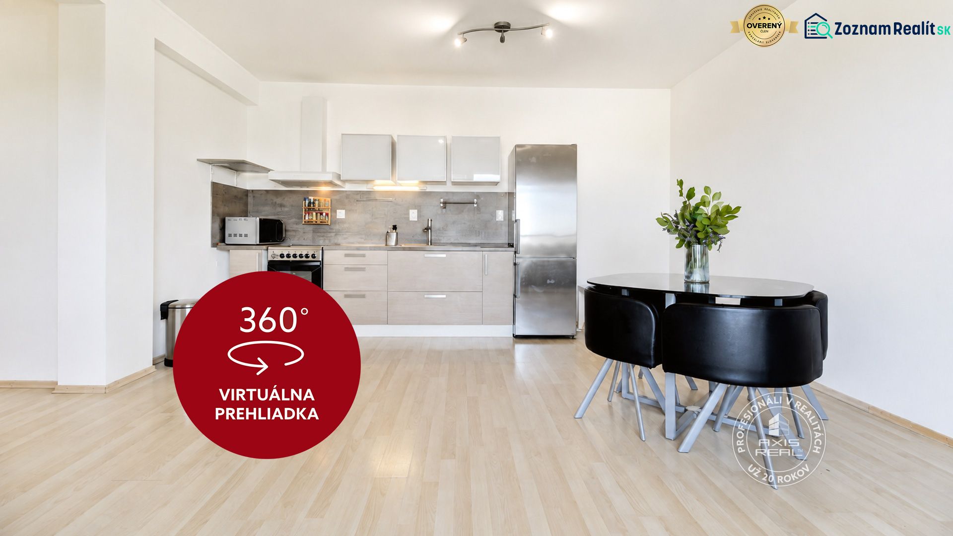 A kitchen in a 2-room apartment with a wooden decor floor and a black table.