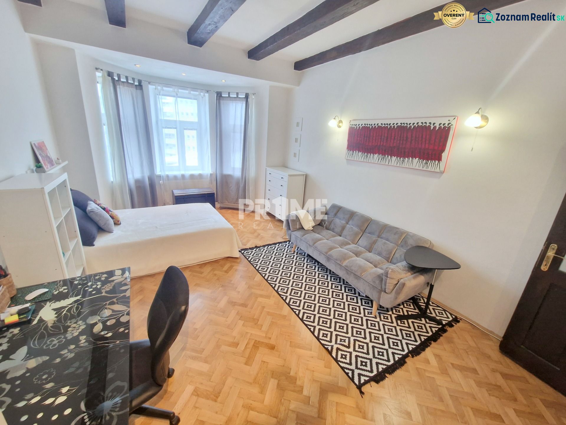 Partially furnished 3-room apartment with a sofa, table, and wooden decor flooring.