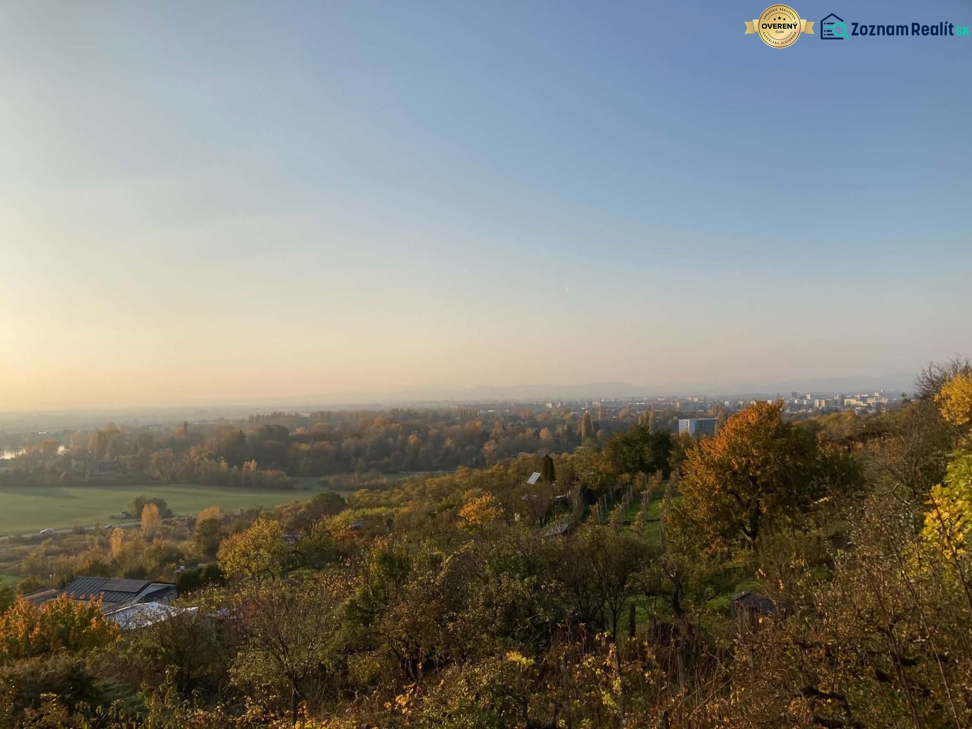 Panorama of the autumn forest and fields with a view of the town of Banka.