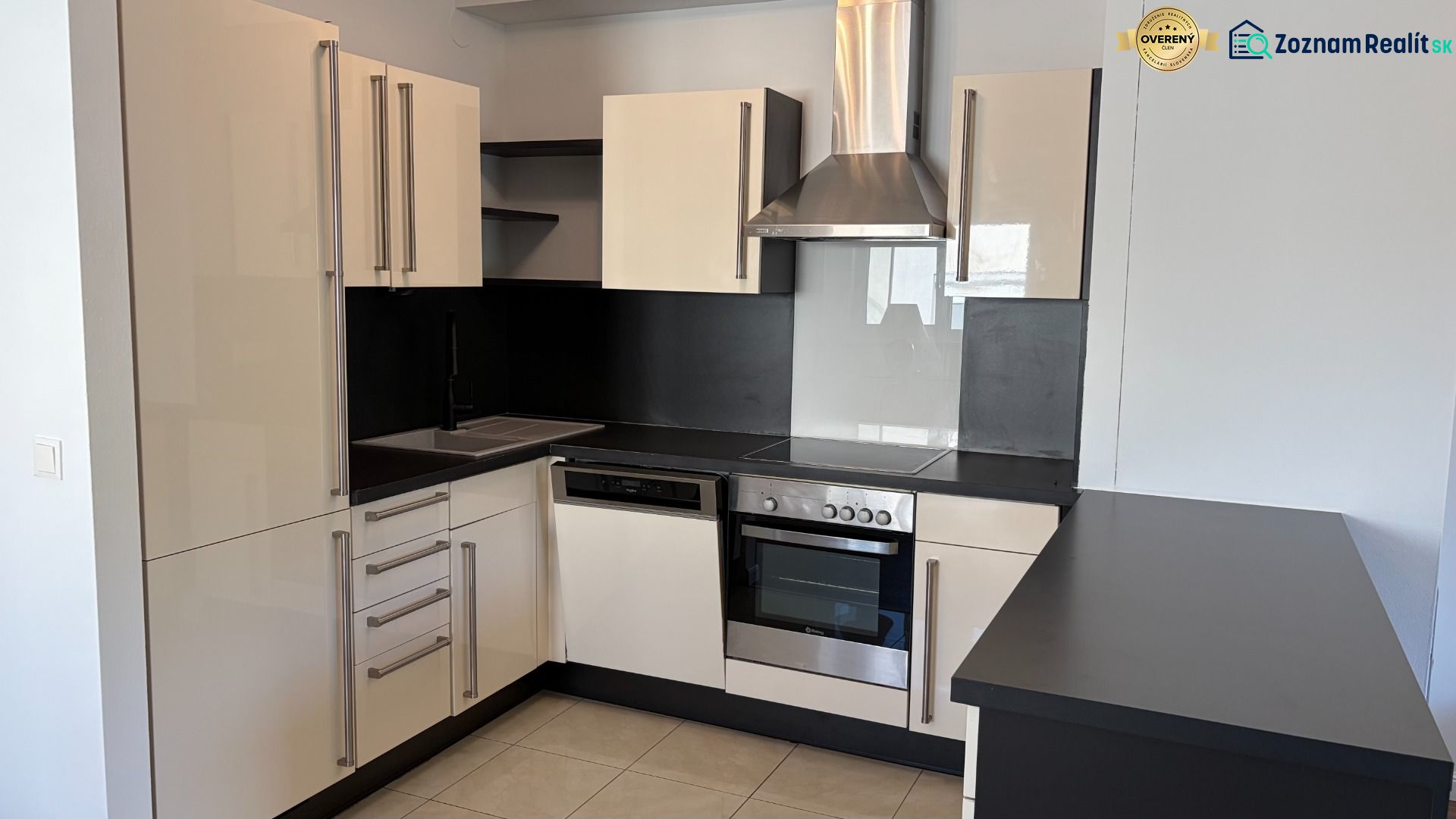 A kitchen in a 3-room apartment, with matching black and white kitchen cabinets and appliances.