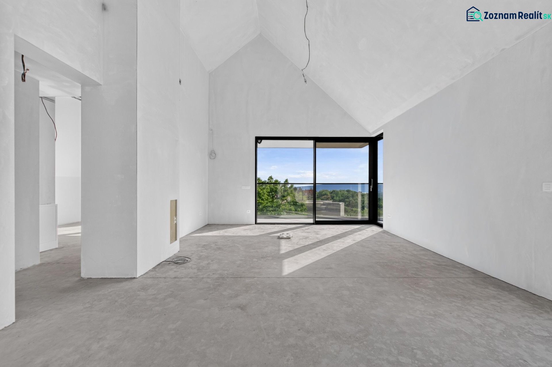 A spacious living room with large windows in a 5 or more room apartment and a view of nature.