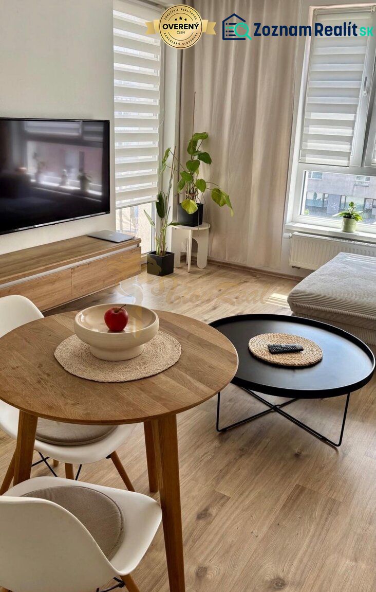 Bright living room in a 2-room apartment with a TV, window, and tables. Floor with wood decor.