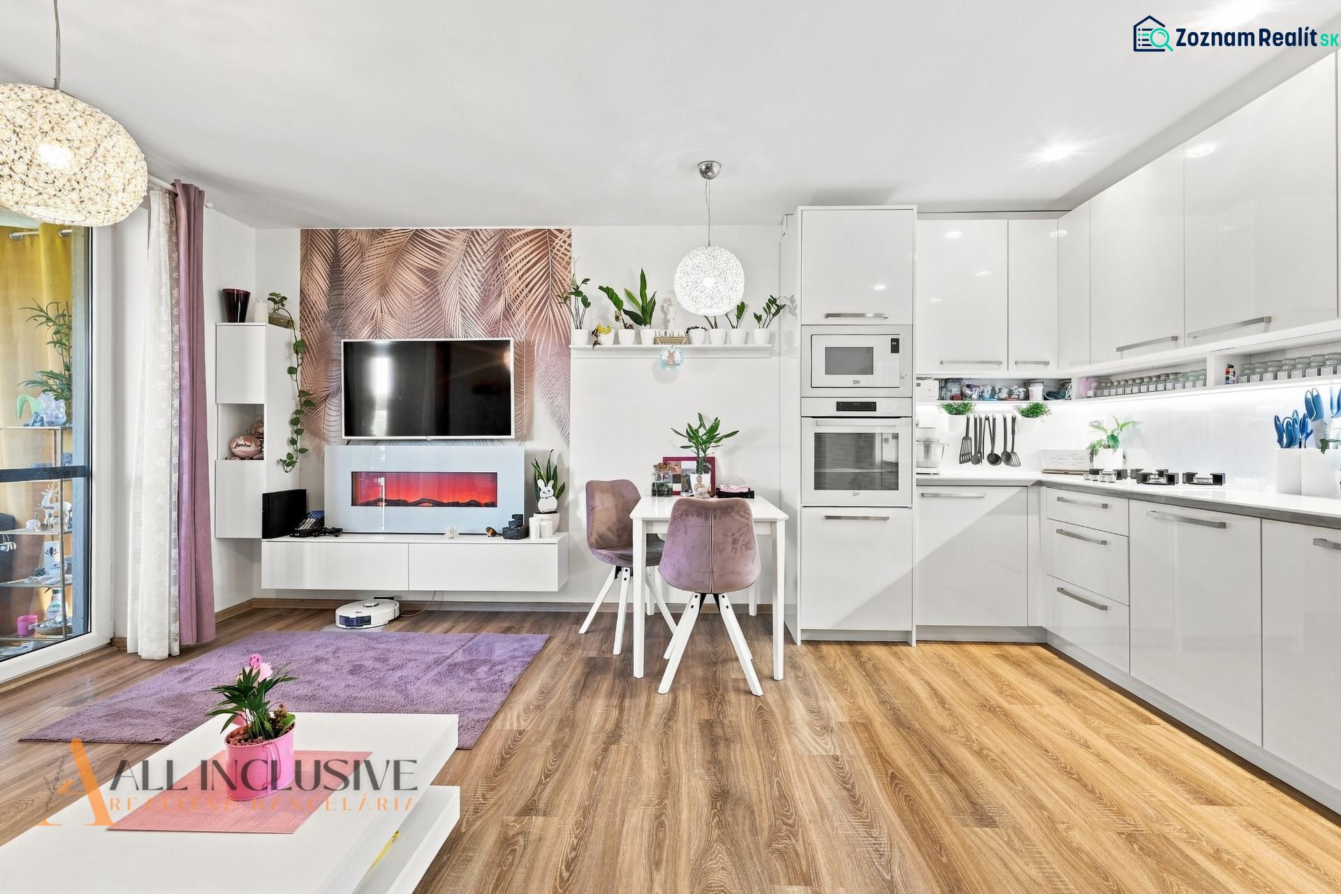Living room in a family house with a kitchen, white furniture, and a wooden decor floor.