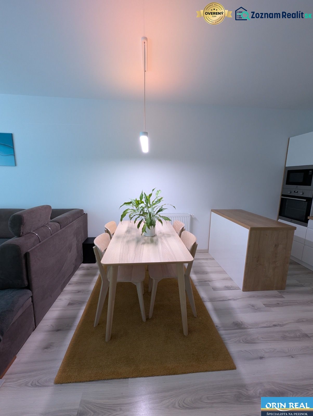 Dining room in a 2-room apartment with a dining table and a wooden decor floor.