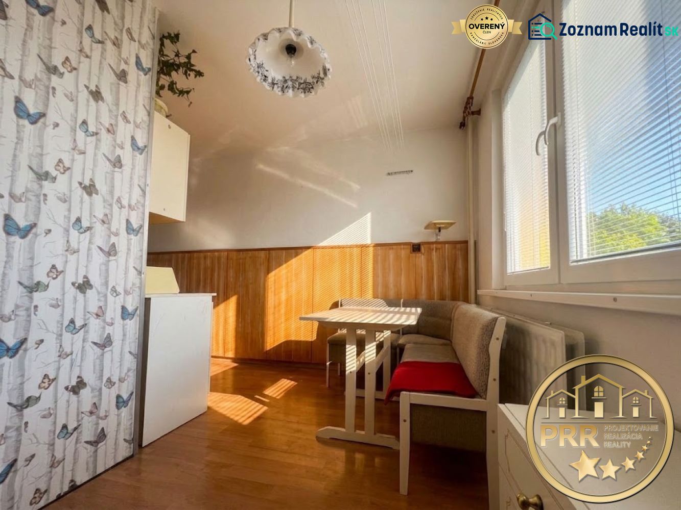 Dining nook in a 2-room apartment with a wooden decor floor and butterfly wallpaper.