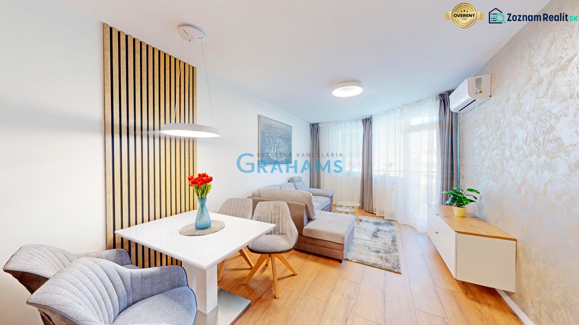 Living room in a two-room apartment with a wooden decor floor and comfortable seating.