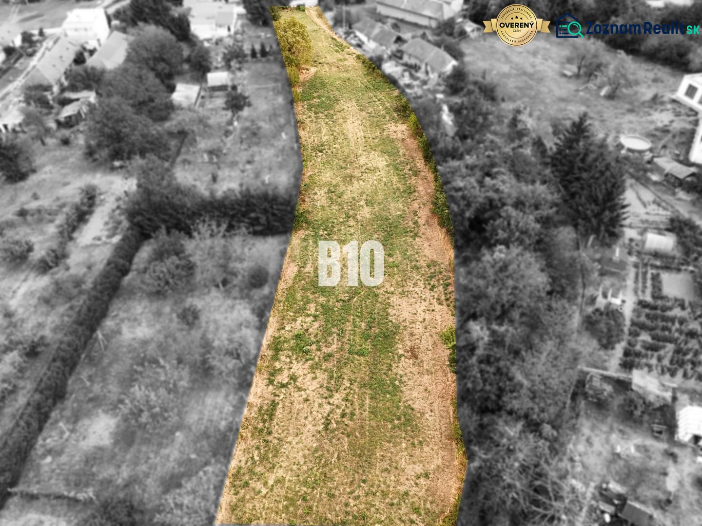 Plots - housing Kolíňany: Long plot with green grass, lined with trees and buildings.