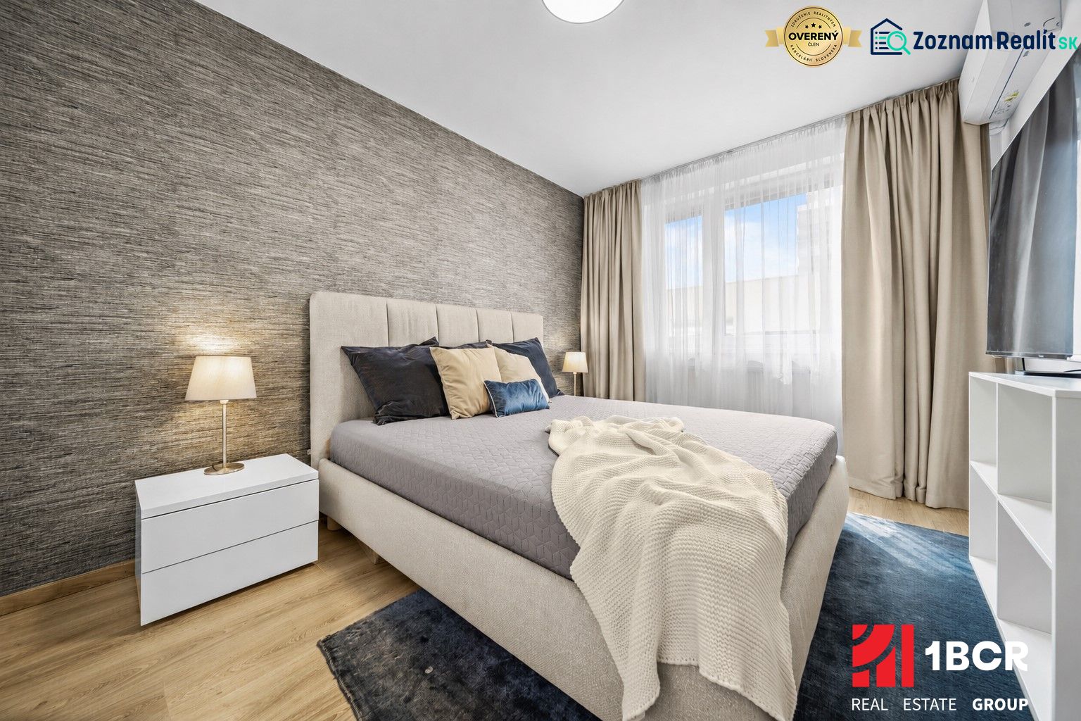 Bedroom with a bed and a nightstand, wooden decor flooring in a 2-room apartment.