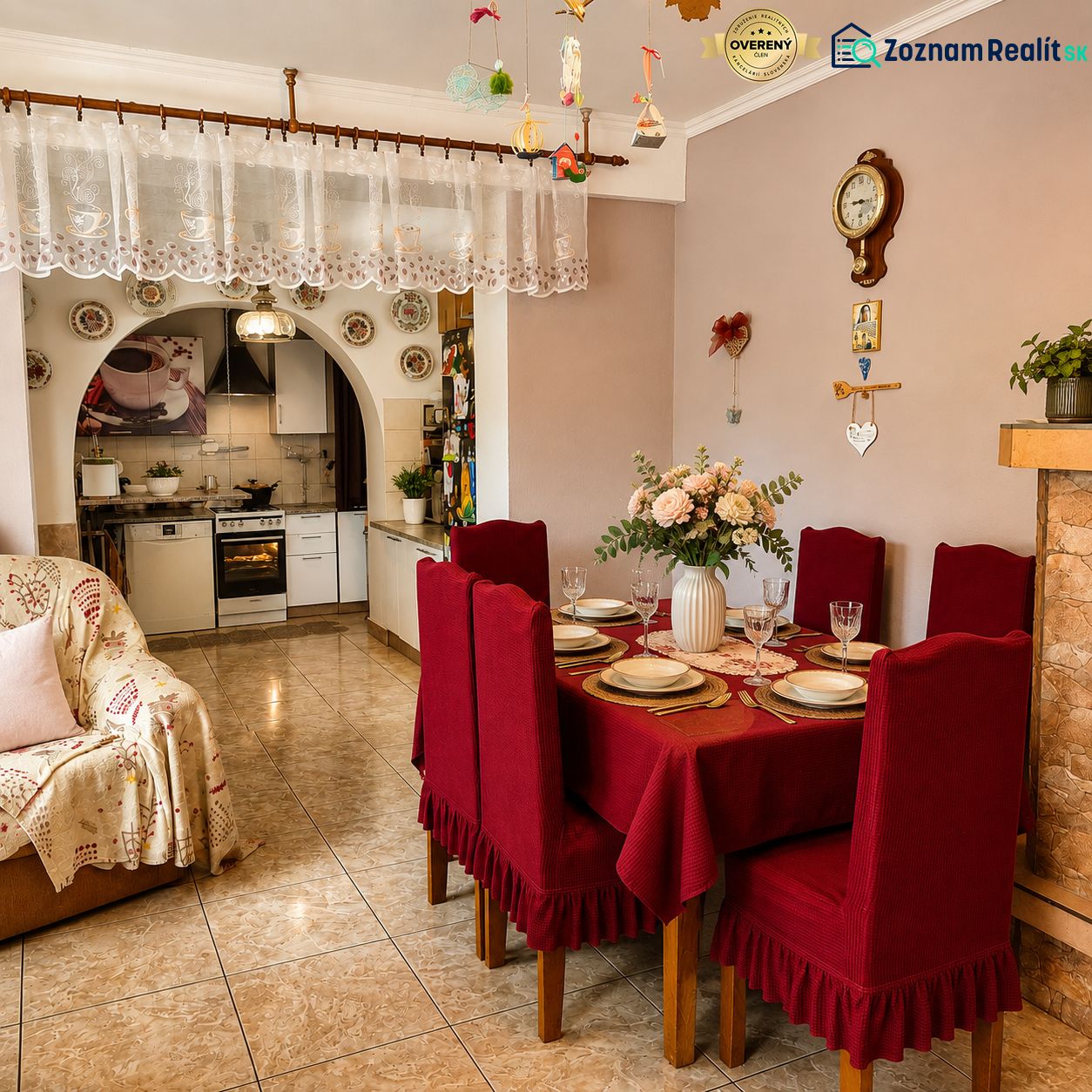 Dining room in a family house with red placemats, a kitchen, and decorations with an antique wall clock.