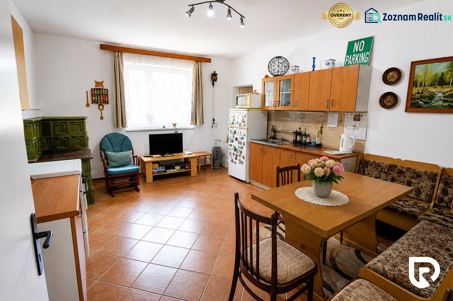 A kitchen in a family house with a fireplace, furniture, and decorations, with a wooden decor floor.