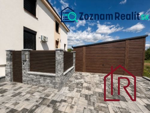 A family house in Kendice with a garage and stone paving.