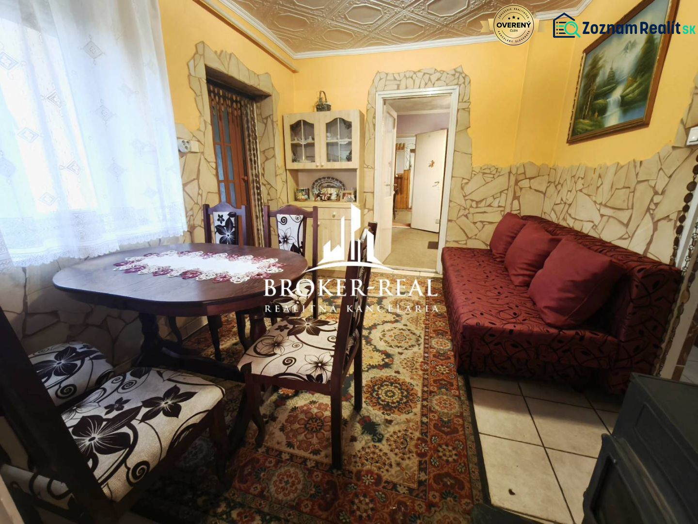 Dining room in a family house with a decorative table and a red sofa.