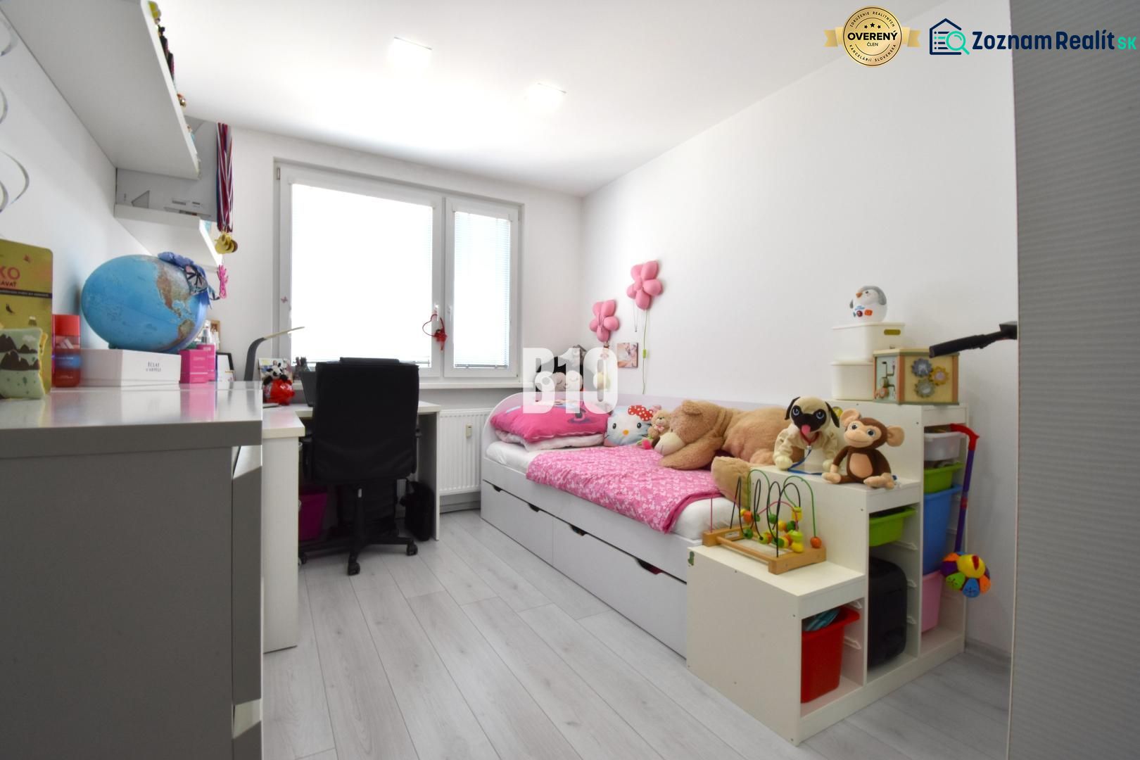 Children's room in a three-room apartment with toys and a writing desk, floor with wooden decor.