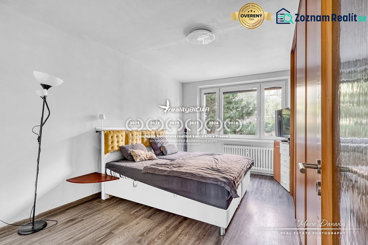 Bedroom with a bed and wooden decor flooring in a two-room apartment.