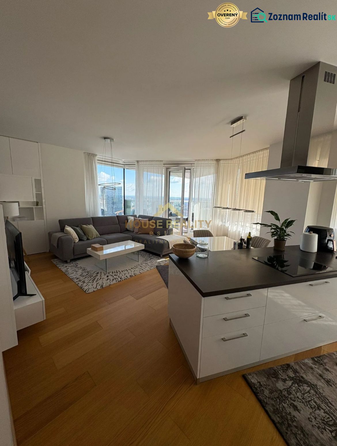 Living room with kitchen, wooden decor flooring, light curtains, 3-room apartment.