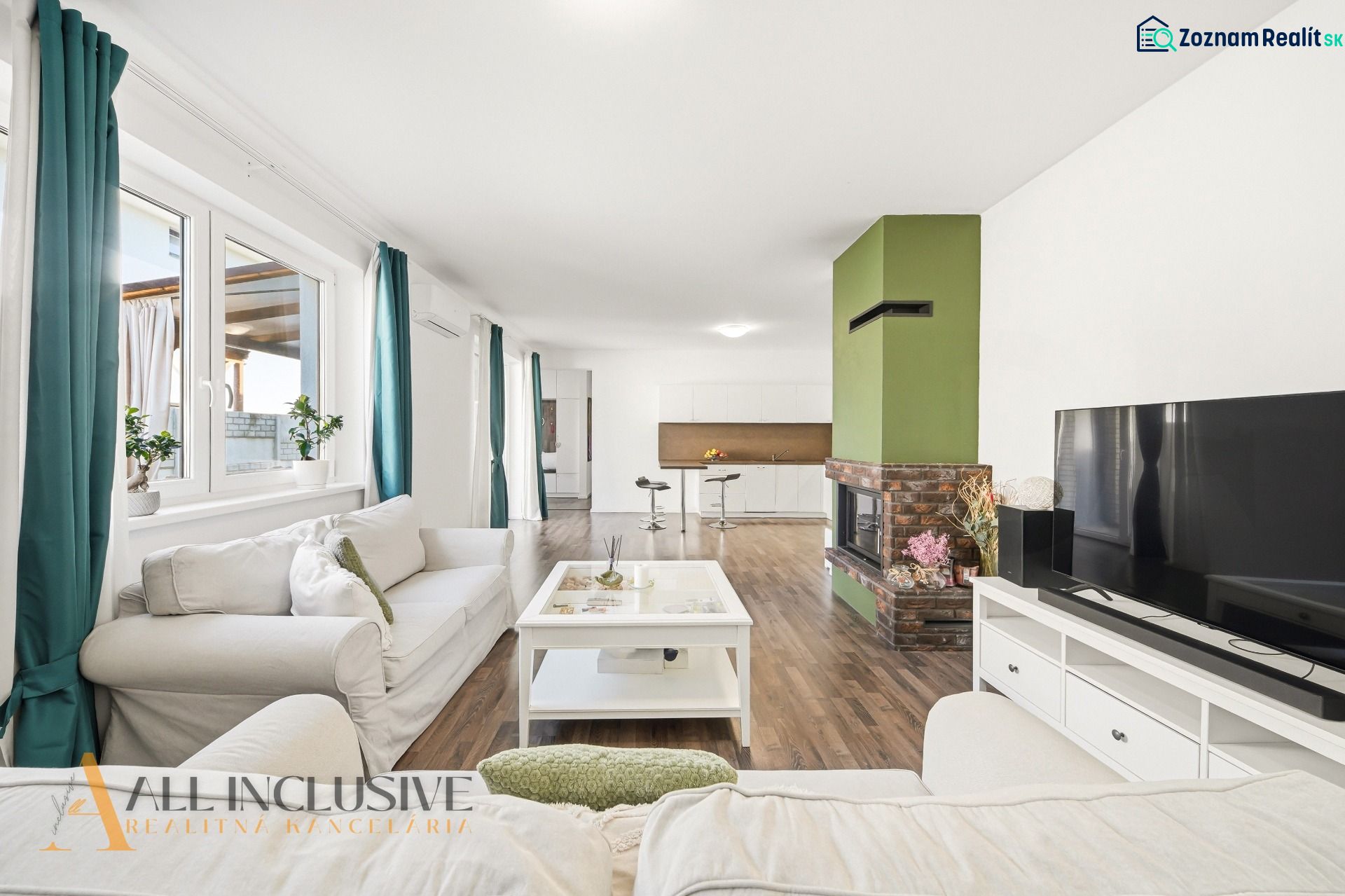 Living room in a three-room apartment with a wooden decor floor and a fireplace.