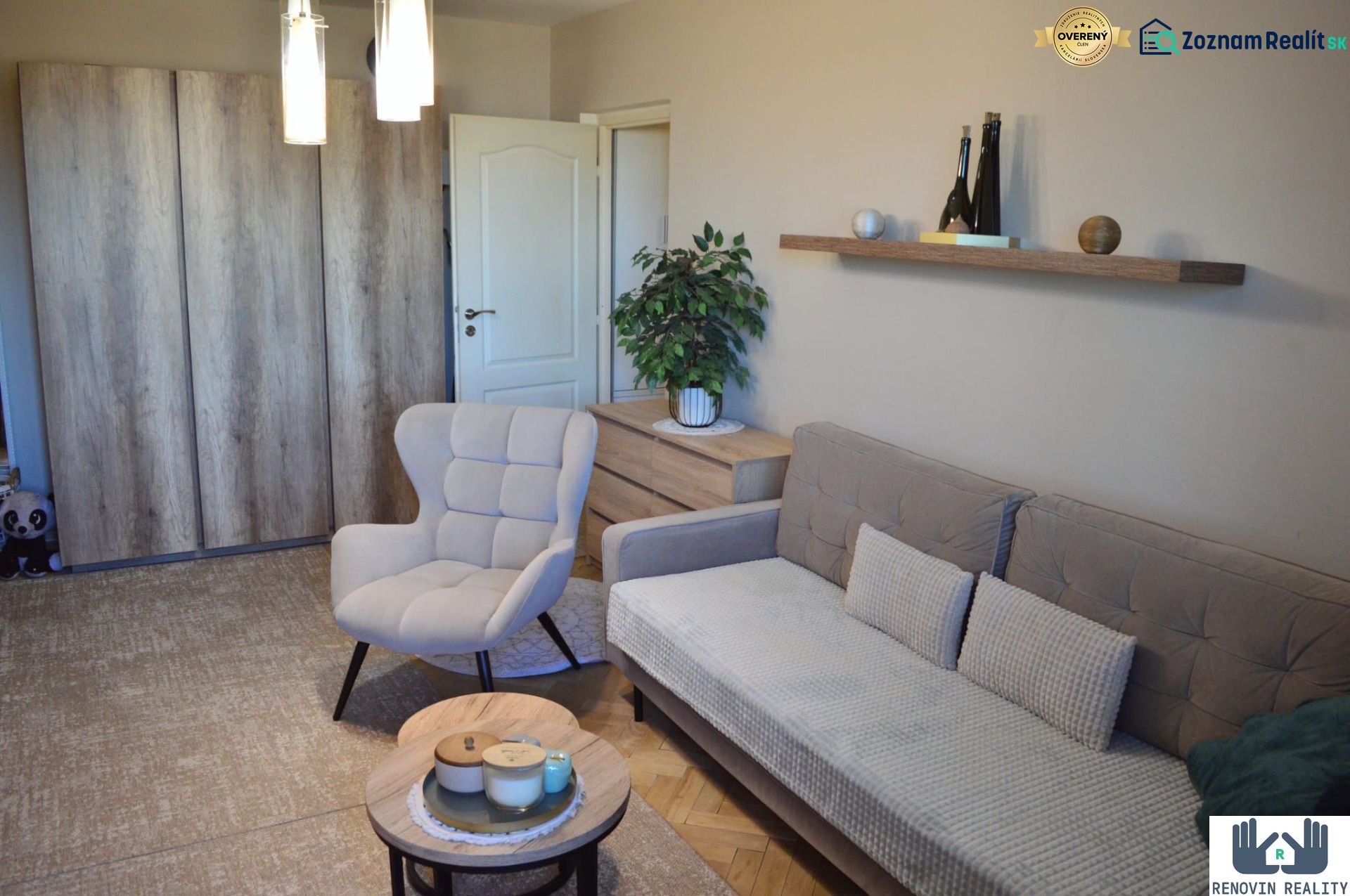 Living room with a sofa, an armchair, and a wooden decor floor in a three-room apartment.