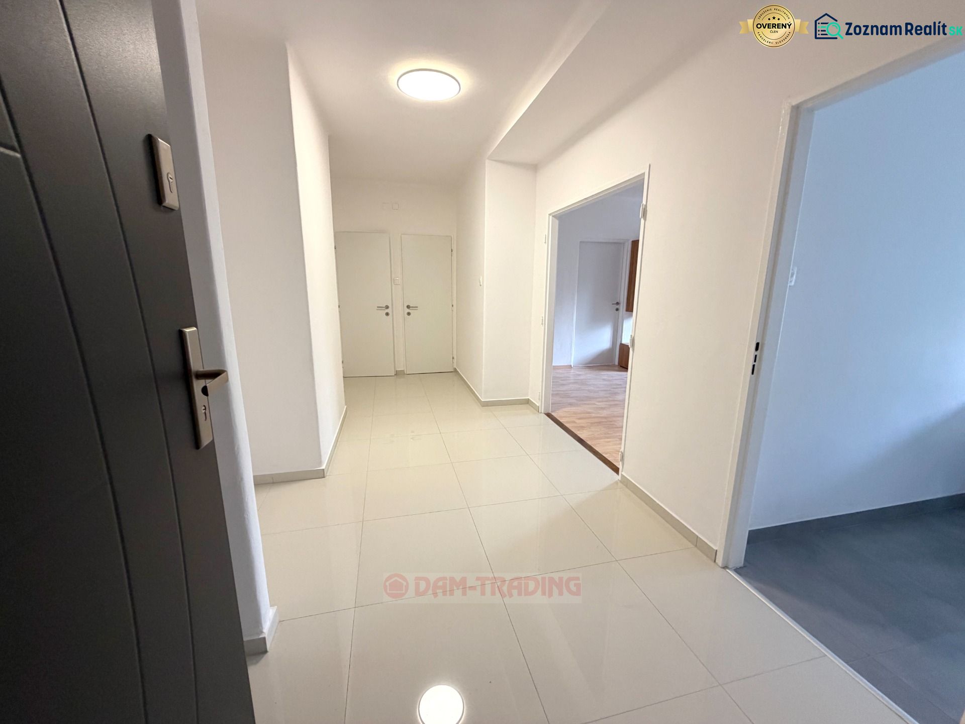 A bright hallway in a 2-room apartment with ceramic flooring and white walls.