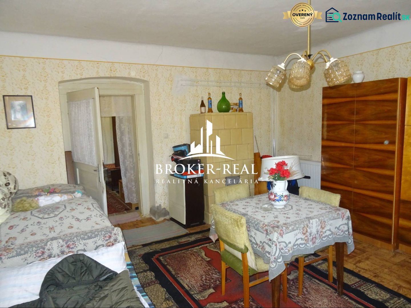 A room in a family house with a tiled stove and a carpet on the floor with a wooden decor.
