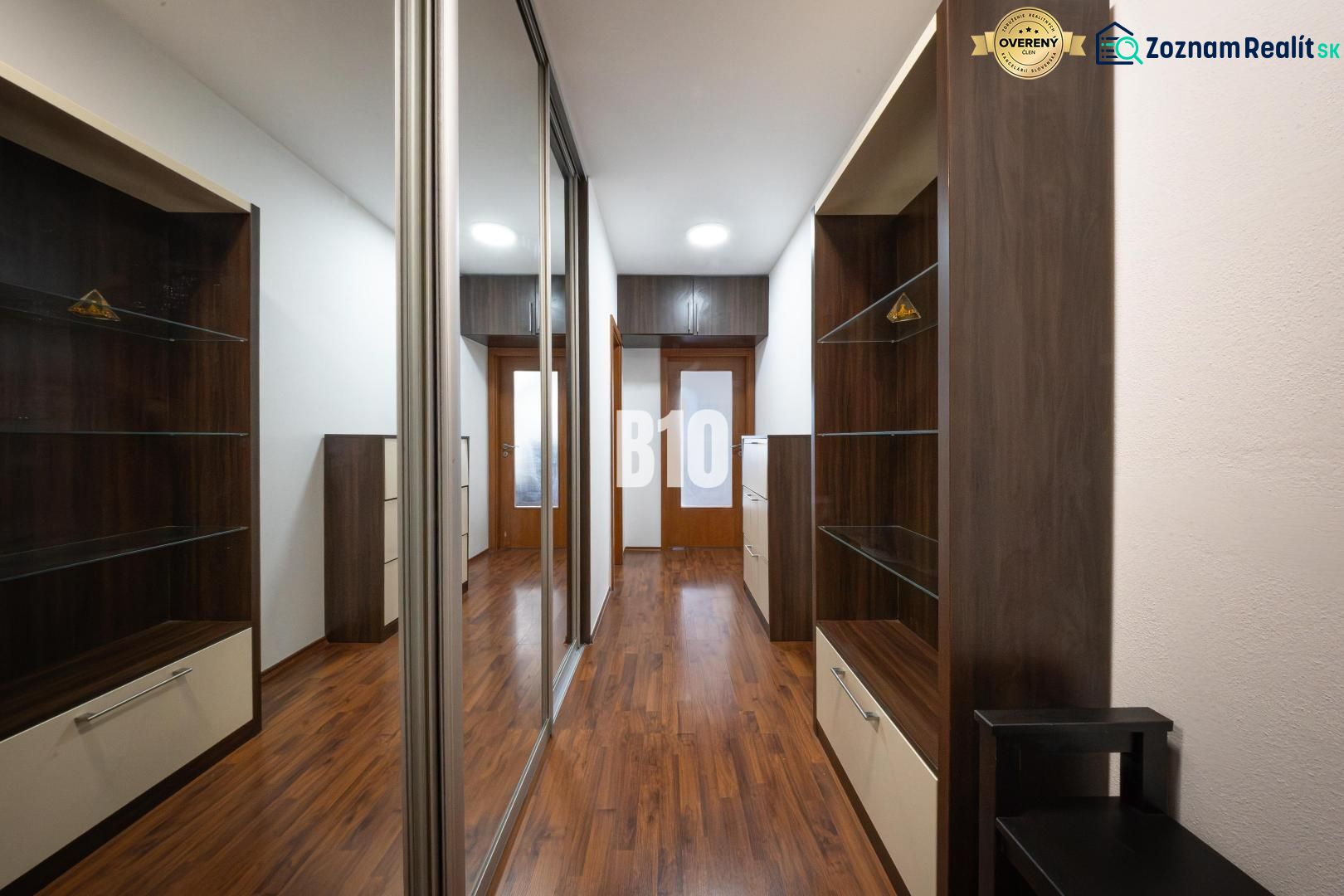 A hallway with a wooden decor floor and built-in wardrobes in a 2-room apartment.