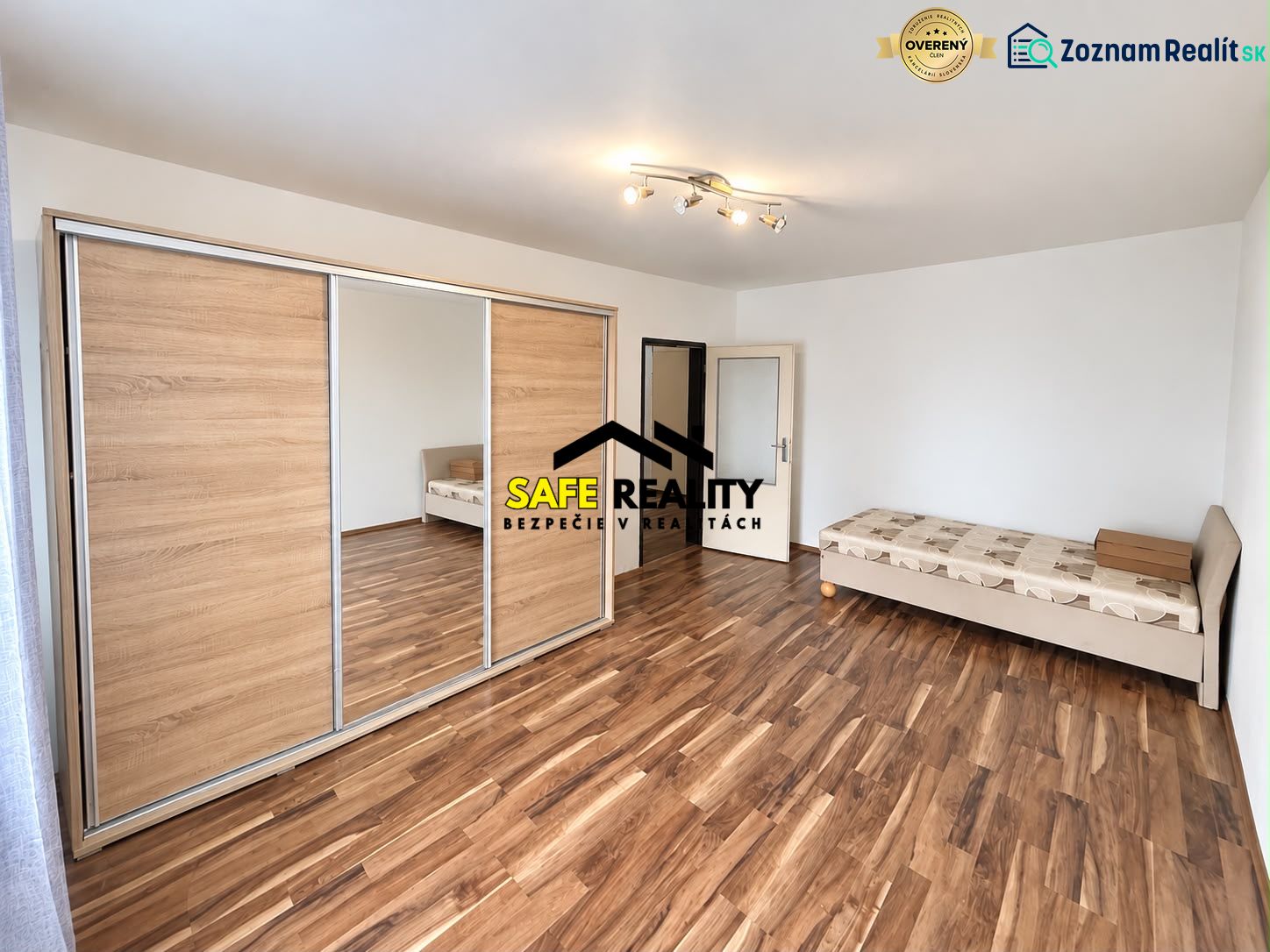 Bedroom in a 3-room apartment with a bed, wardrobe, and floor with wooden decor.