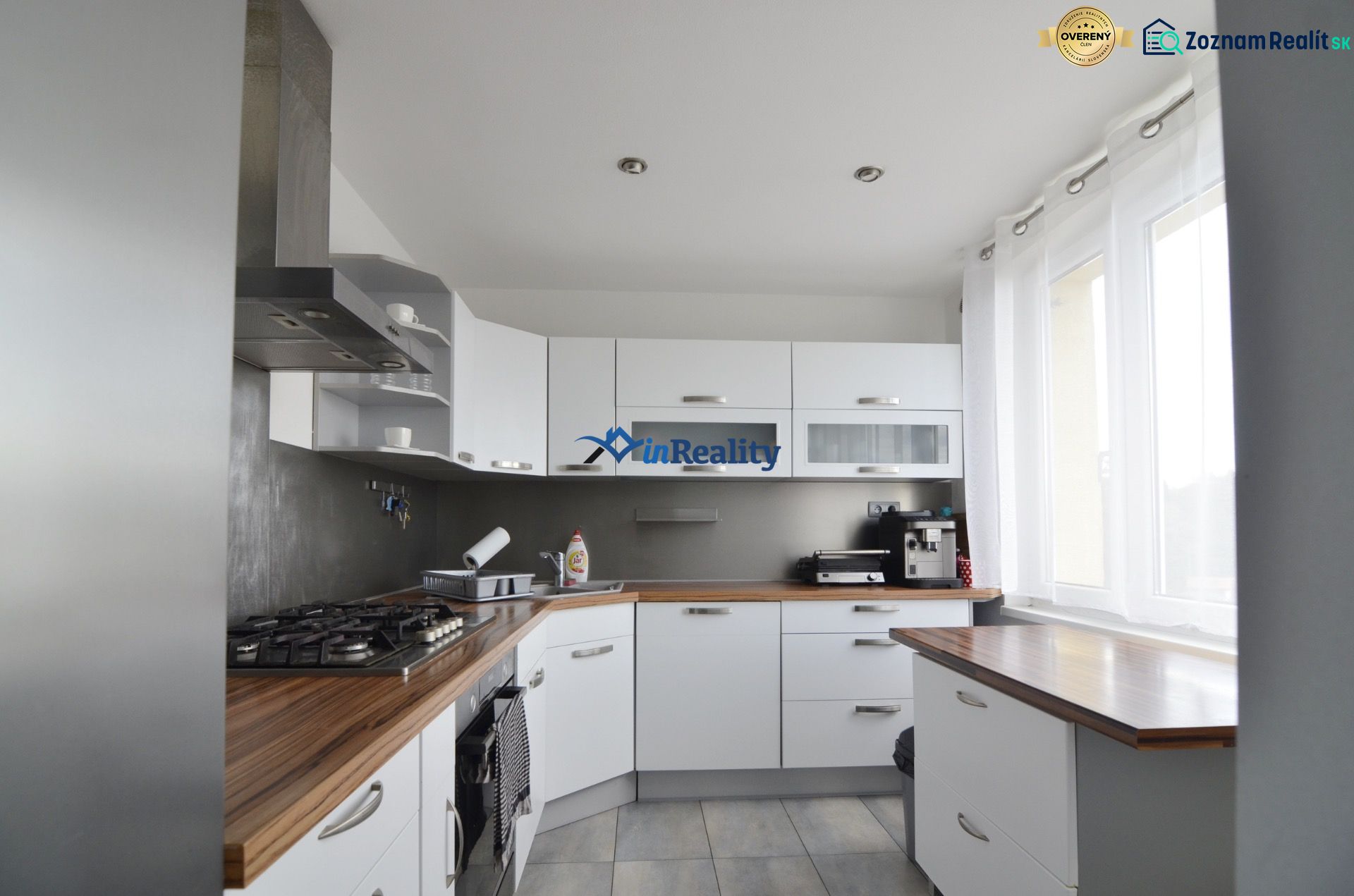 A kitchen in a 4-room apartment with built-in appliances and a floor with a wooden decor.