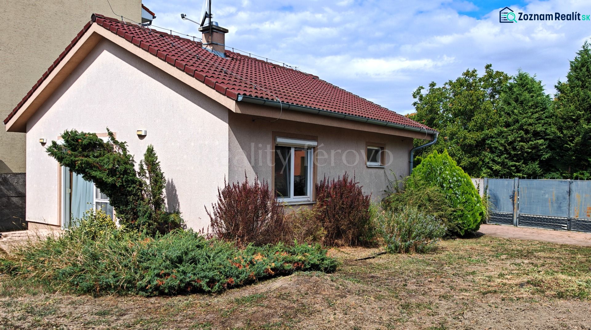 A family house in Matúškovo with a red roof and a well-maintained front garden.