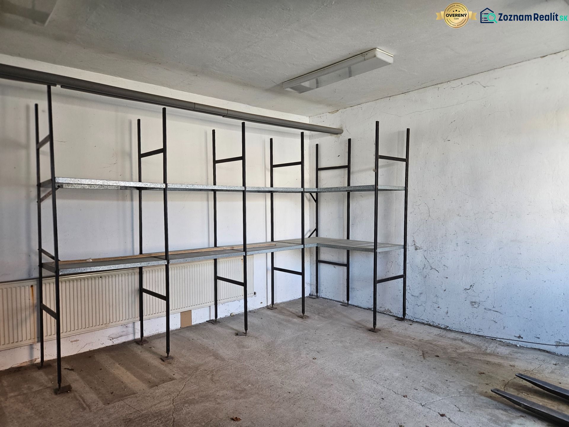 Shelves in a garage with a concrete floor and white walls.