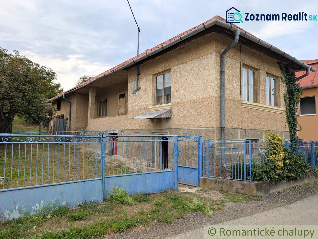 A family house in Nižné Ladičkovce with a blue fence and a garden.